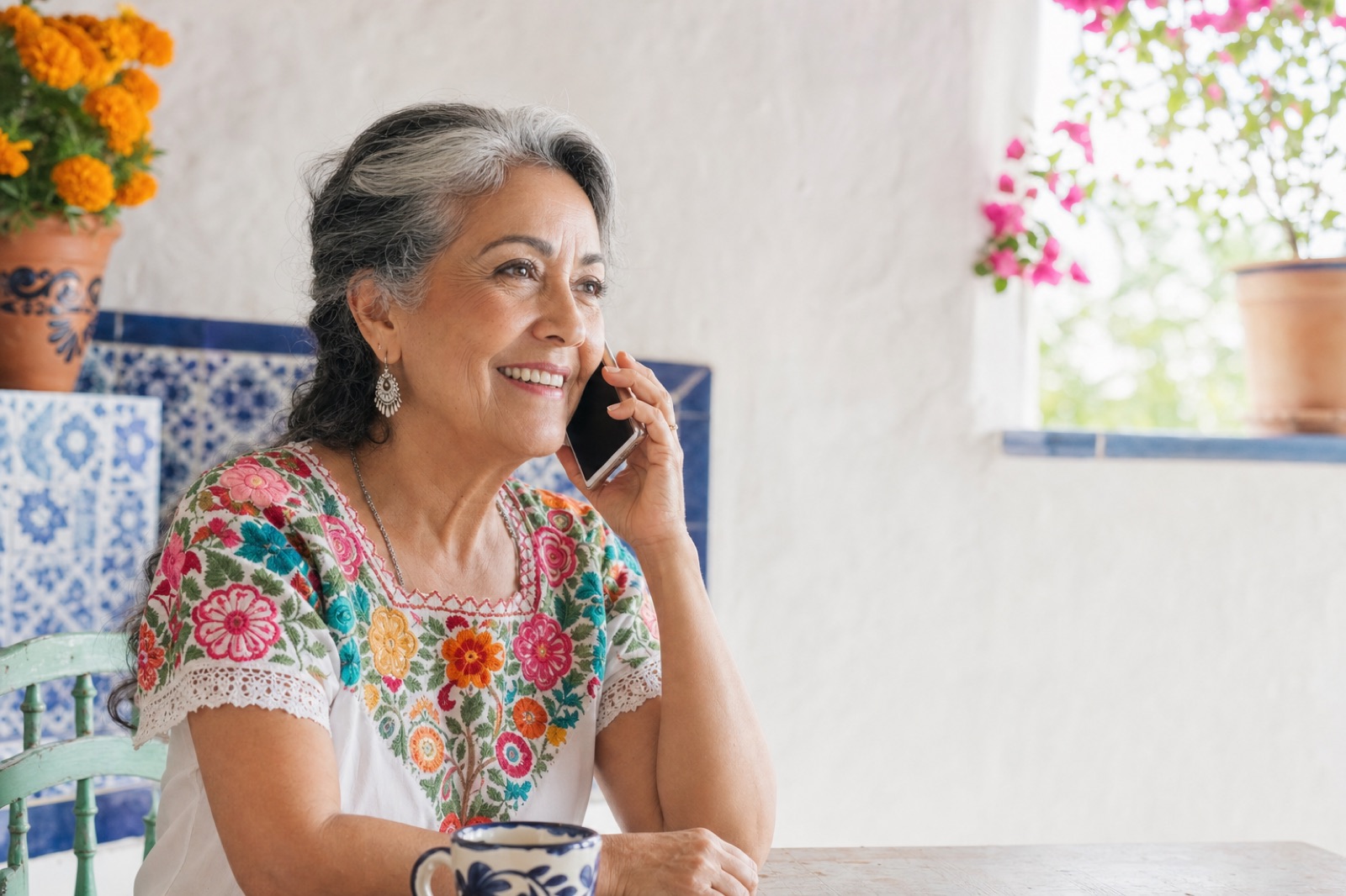 Una mujer sonríe mientras habla por teléfono en su cocina